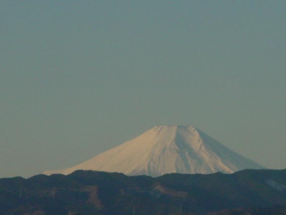 ④晴れた日の早朝、職場から南西方向の風景だそうです。米軍横田飛行場のむこうに見える朝焼けの富士山。